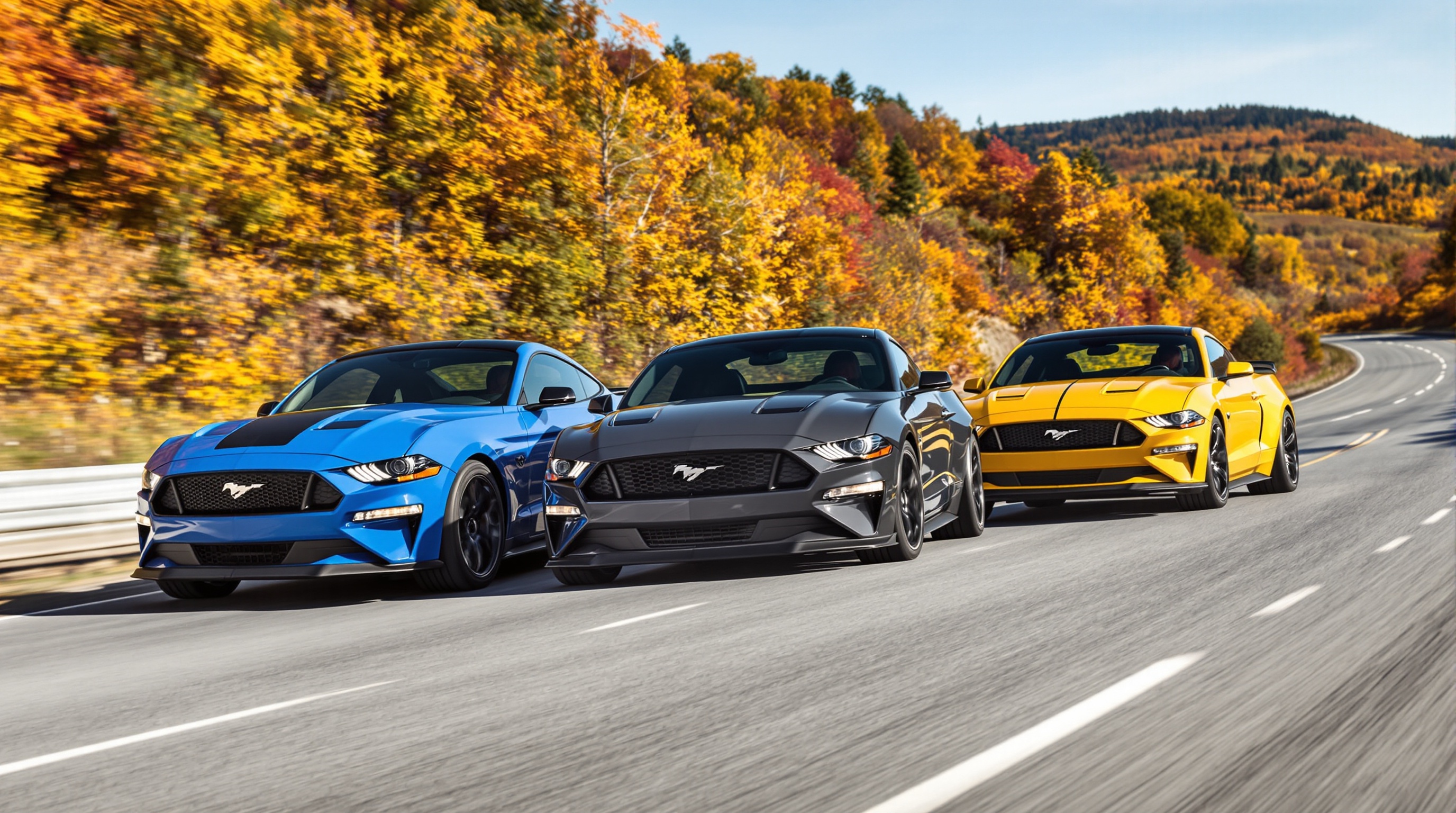 3 Mustang Mach-E alignées versions Propulsion AWD GT route sinueuse automne dynamique