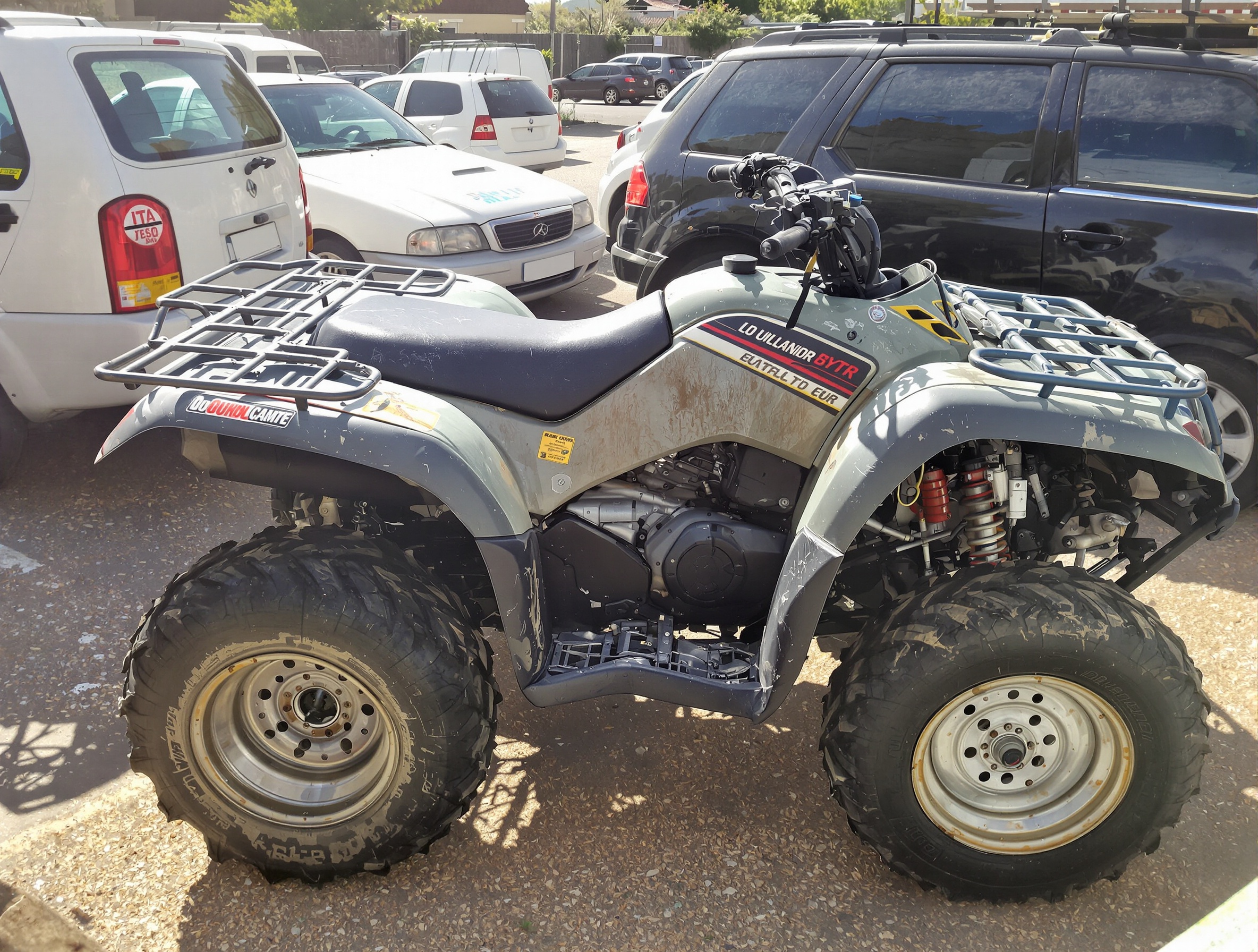 Quad d’occasion sur parking en Occitanie, détails carrosserie visible.